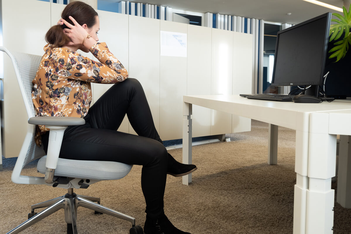 Frau macht Bauchmuskel-Training am Schreibtisch