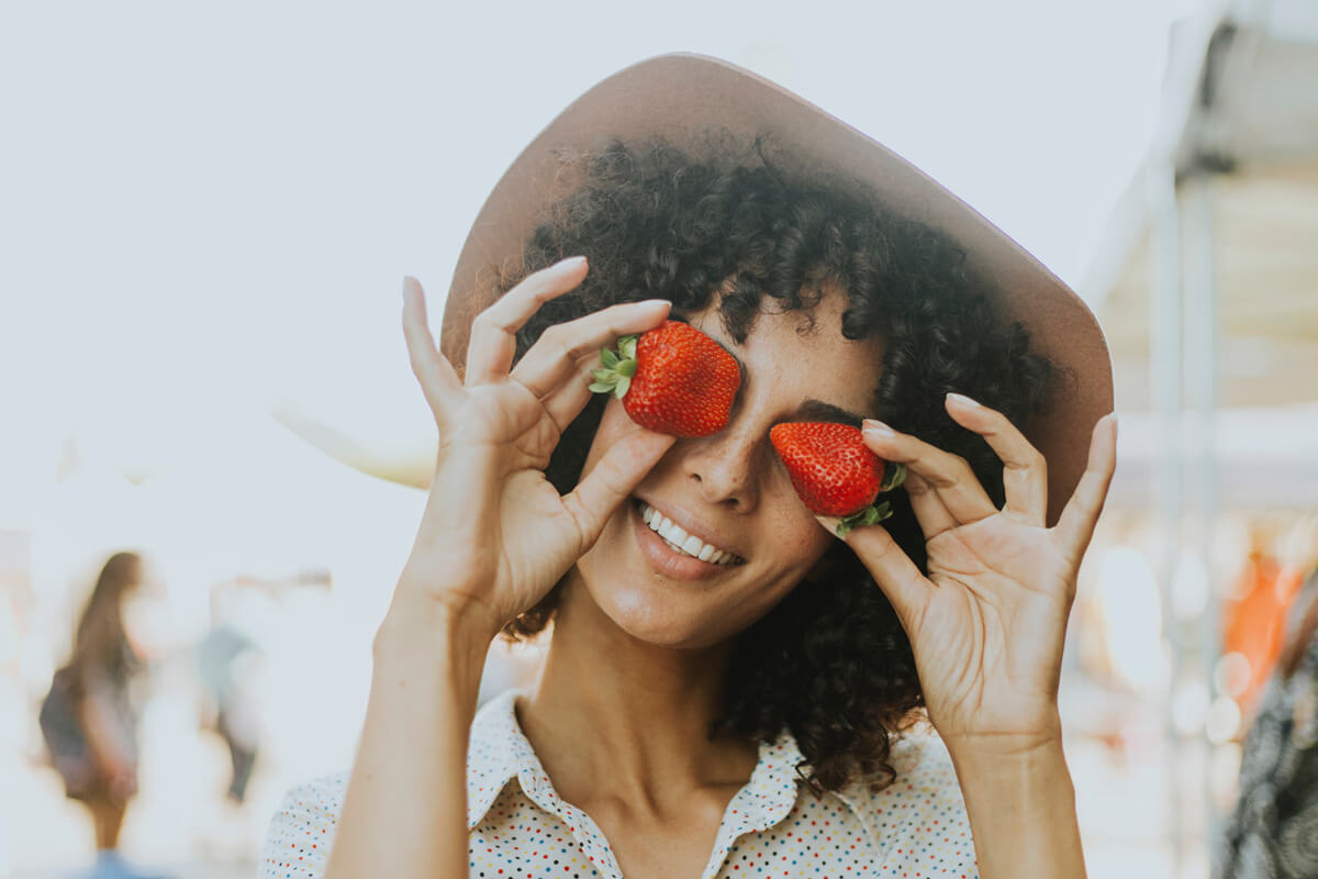 Frau mit Hut und Erdbeeren
