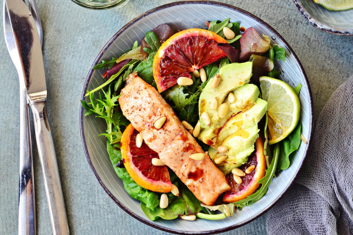 EIn Fischgericht mit Salat, Avocado und Blutorange